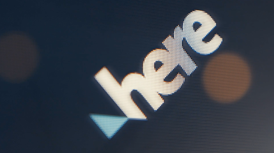 Illuminated HERE wordmark emerging from a dark digital surface